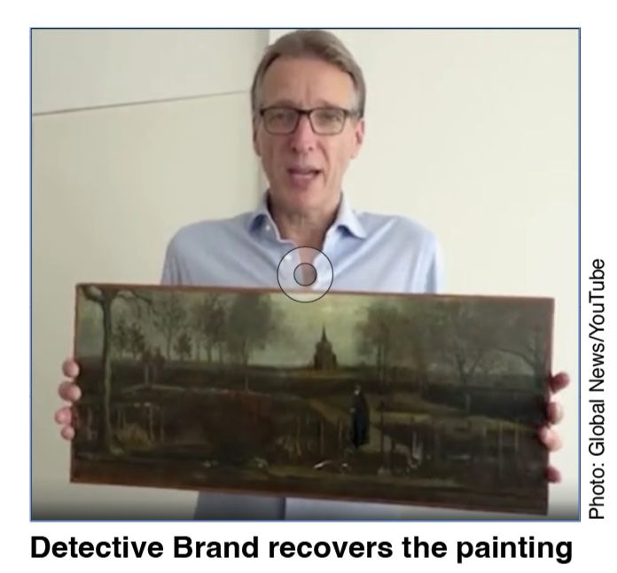 Detective Brand recovers the painting and holding it up for people to see. 